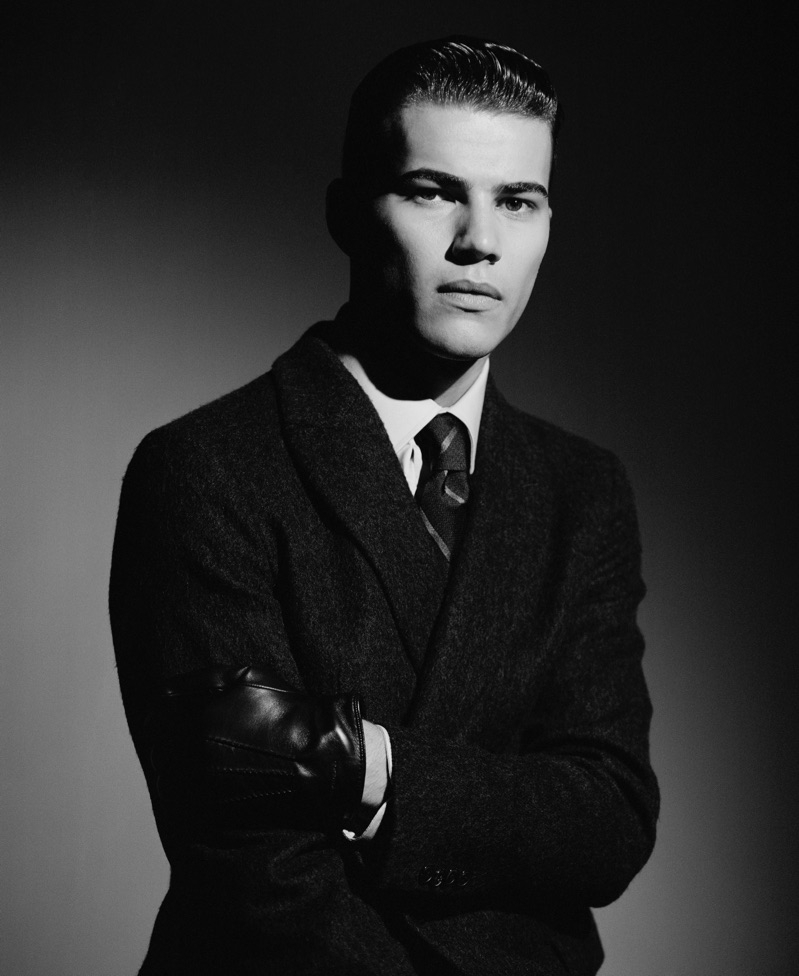 Louie Warner wears a double-breasted coat, shirt, and tie from Giorgio Armani.