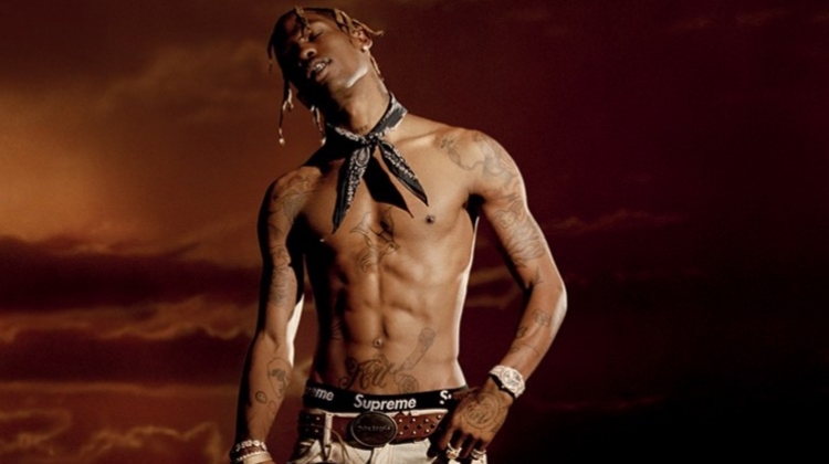 Posing for a new photo shoot, Travis Scott goes shirtless in a Palm Angels belt and trousers with an Alexander Wang bandana.