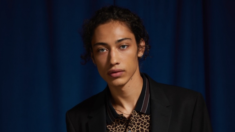 Max Fieschi models an UO black skinny fit blazer and suit pants with a Lacoste leopard print polo.
