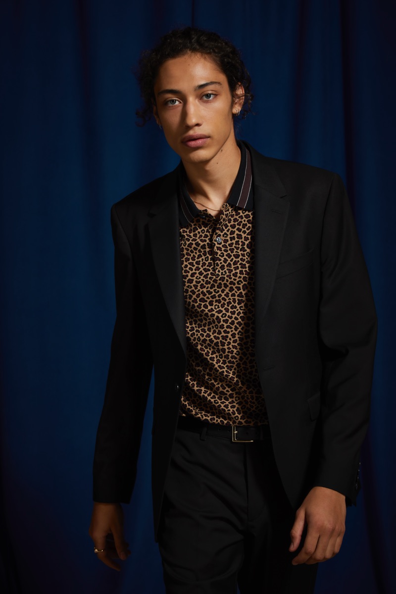 Max Fieschi models an UO black skinny fit blazer and suit pants with a Lacoste leopard print polo.