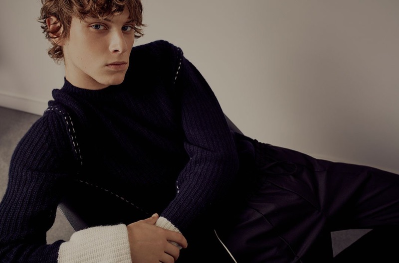 Relaxing, Serge Sergeev wears a sweater and track pants by Valentino.