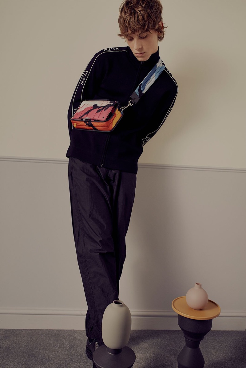 Model Serge Sergeev sports a Valentino logo track top, jacquard belt trousers, leather derby shoes, and a cross-body bag. » Serge Sergeev is the Valentino Man for Matches Fashion Model Serge Sergeev sports a Valentino logo track top, jacquard belt trousers, leather derby shoes, and a cross-body bag.