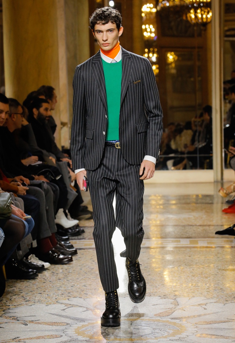 Piero Mendez dons Versace's pinstripe suit during the label's fall-winter 2018 menswear show.