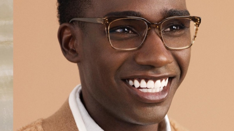 All smiles, Bakay Diaby dons Warby Parker's Hughes glasses in Chestnut Crystal.