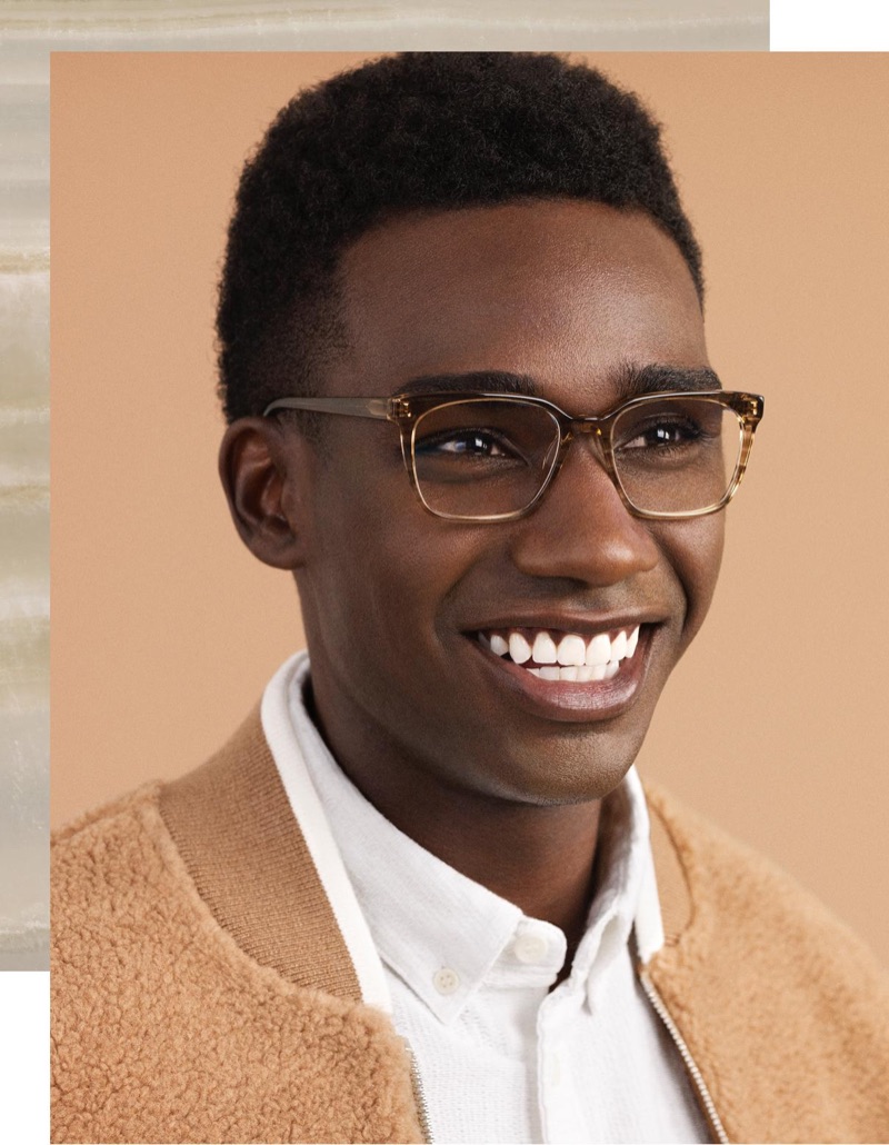 All smiles, Bakay Diaby dons Warby Parker's Hughes glasses in Chestnut Crystal.