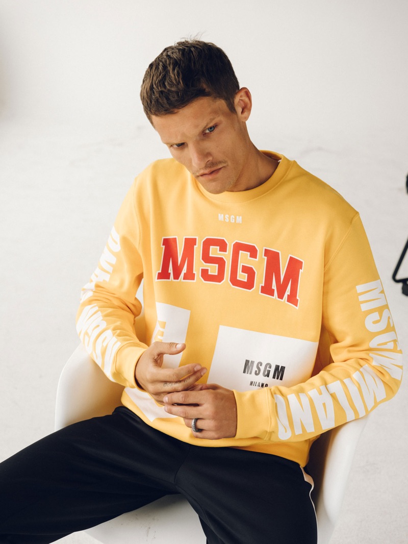 Embracing a pop of color, Danny Beauchamp wears a yellow MSGM sweatshirt.