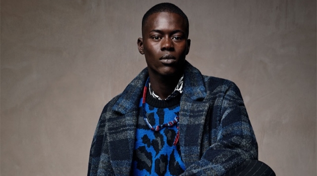 Alpha Dia dons a leopard print sweater with a check coat and pinstripe trousers from Zara Man.