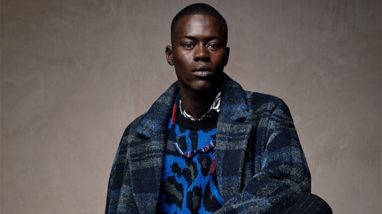 Alpha Dia dons a leopard print sweater with a check coat and pinstripe trousers from Zara Man.