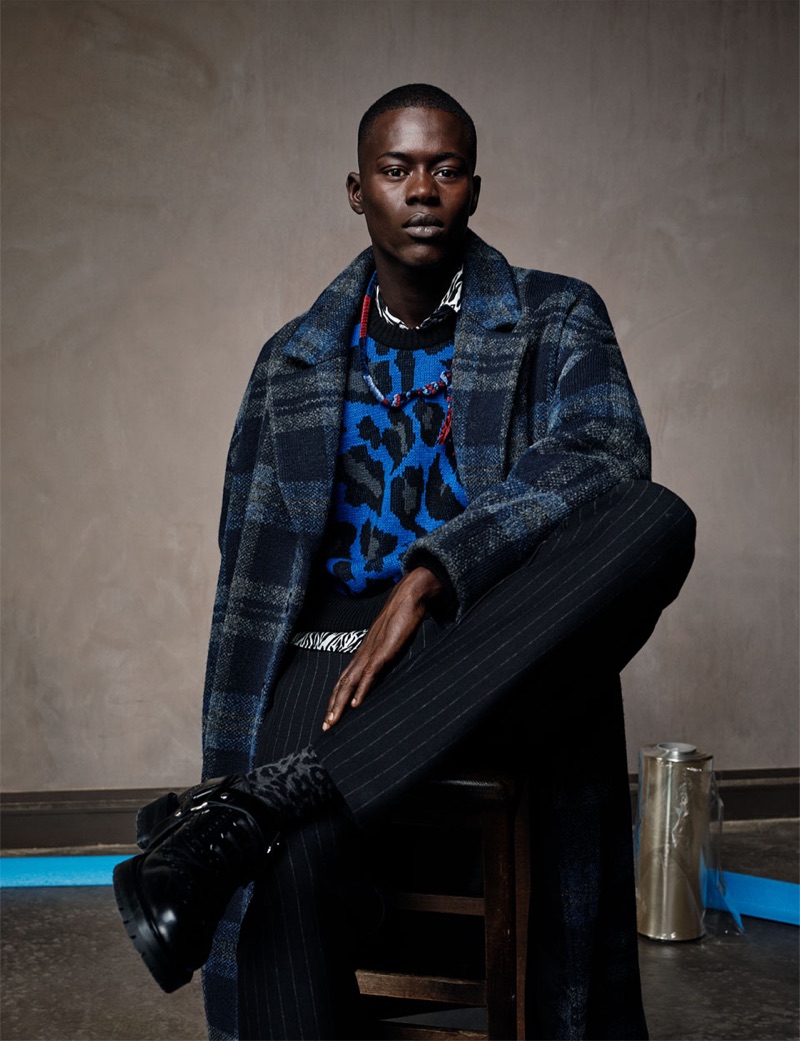 Alpha Dia dons a leopard print sweater with a check coat and pinstripe trousers from Zara Man.