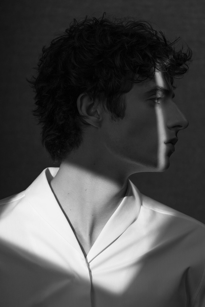 Delivering a side profile, Oscar Kindelan dons a minimal white shirt by COS.