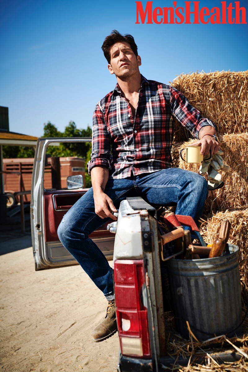 Embracing rugged style, Jon Bernthal wears an Eleventy shirt, Dolce & Gabbana jeans, Allen Edmonds boots, and a Movado watch.