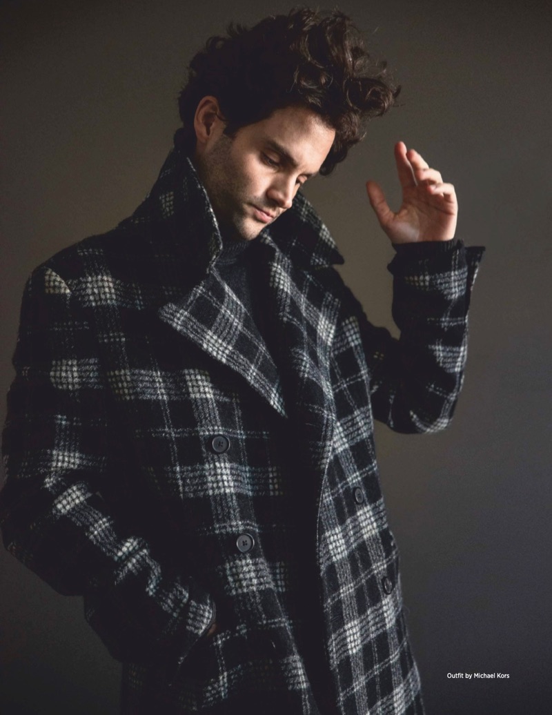 Channeling his inner model, Penn Badgley dons a checked coat by Michael Kors with a sweater.