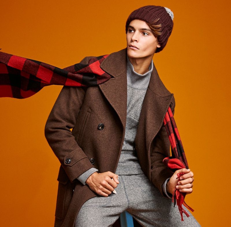 Embracing winter, Parker van Noord dons a brown Todd Snyder Italian yak hair officer coat with a Joshua Ellis red buffalo check cashmere scarf.