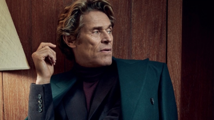 A sleek vision, Willem Dafoe wears a Paul Smith double-breasted coat with a sweater and suit by Gieves & Hawkes.