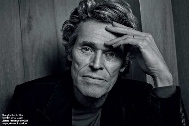 Captured in black and white, Willem Dafoe wears a Giorgio Armani velvet jacket with a Gieves & Hawkes sweater.