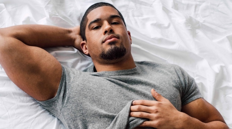 Laying in bed, Anthony Bowens stars in a photo shoot for Gay Times.