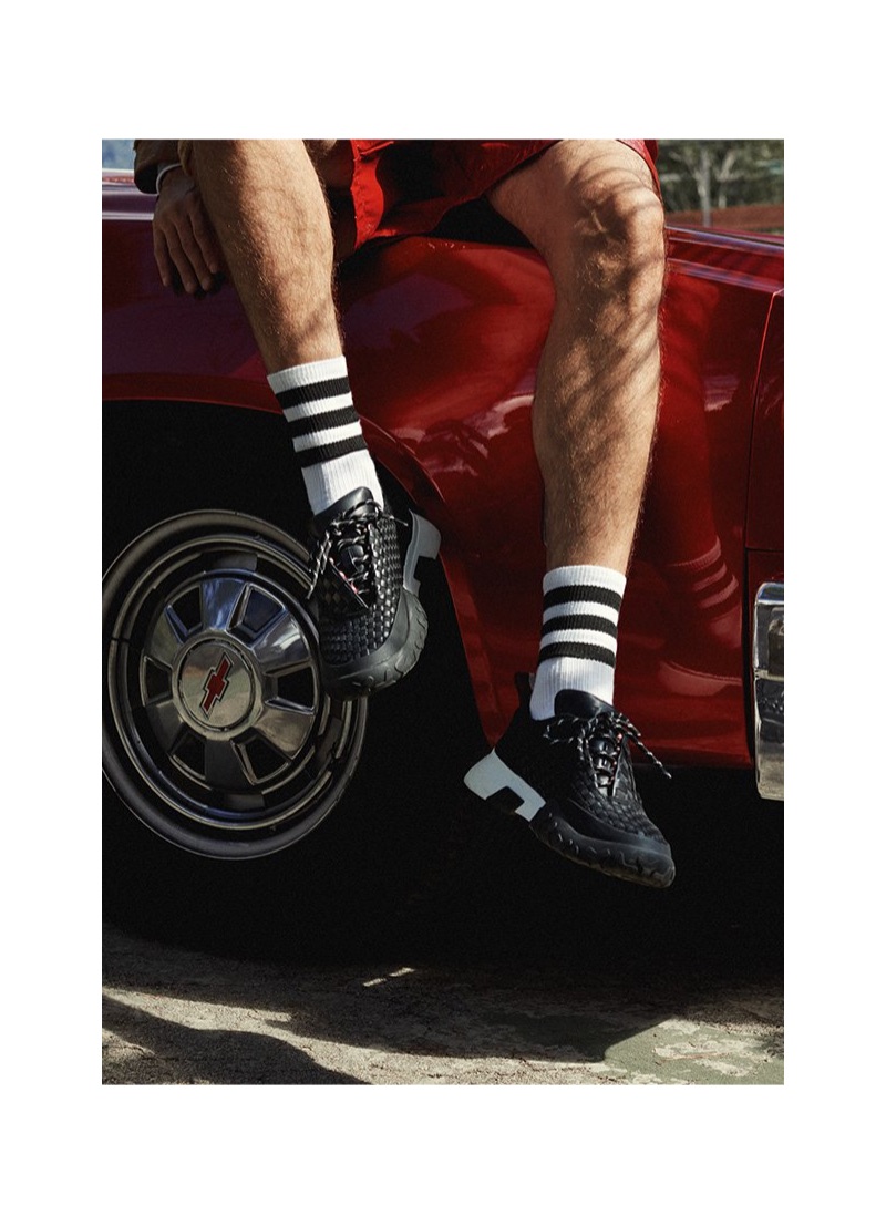 A sporty aesthetic reigns with black sneakers and tube socks from Bally.