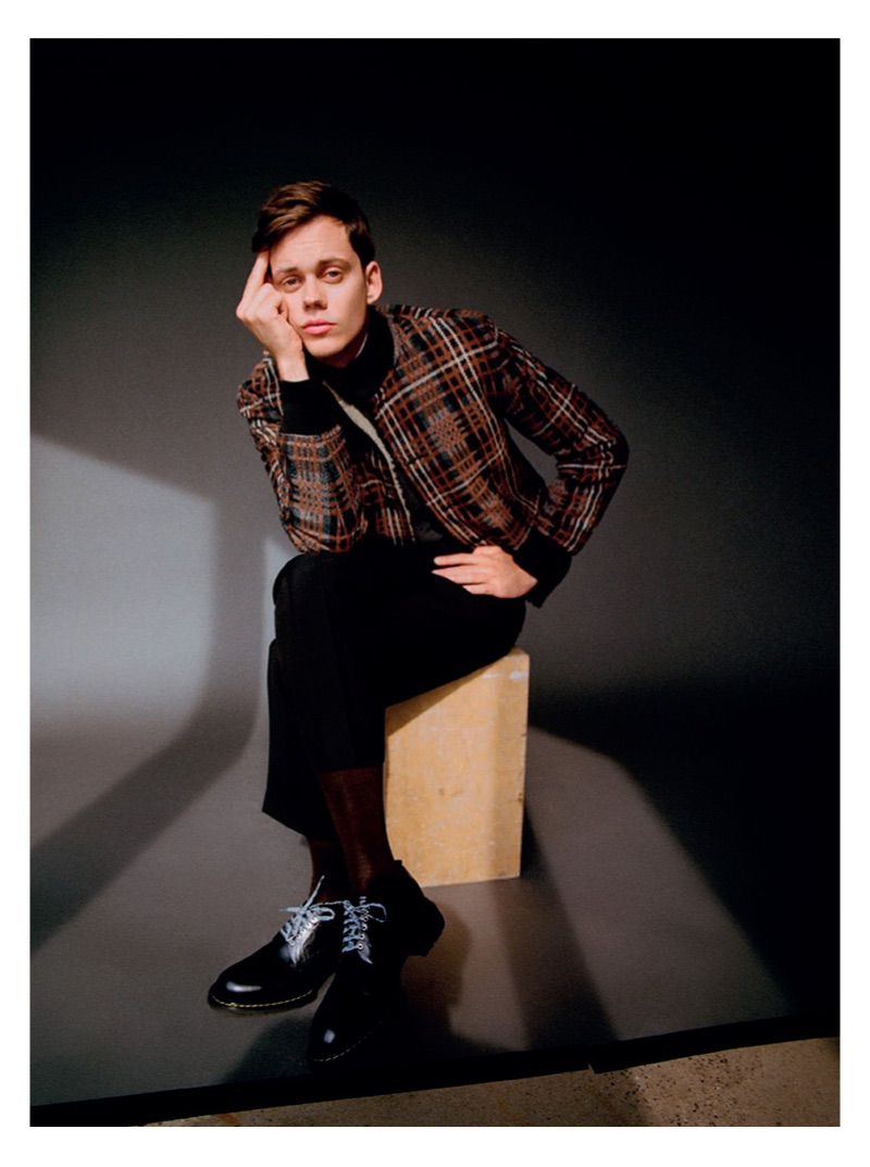 Making a graphic statement, Bill Skarsgård sports a checked Cerruti 1881 bomber jacket and pants with a Mango sweater. He also rocks a Dior Men shirt and shoes.