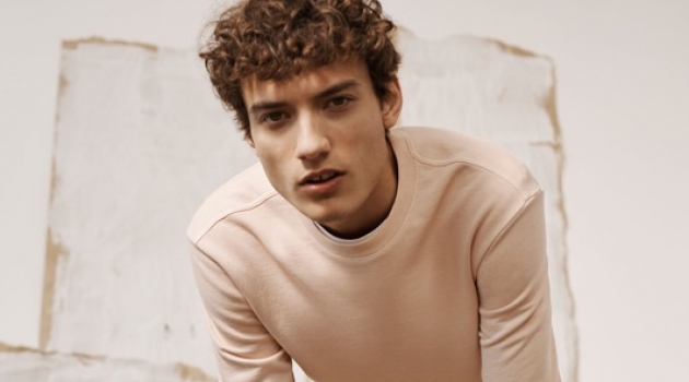 Starting Now: Serge Rigvava Dons Smart New Club Monaco Styles Embracing light hues, Serge Rigvava wears a pink sweatshirt with Connor stretch chinos by Club Monaco.