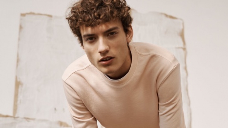 Embracing light hues, Serge Rigvava wears a pink sweatshirt with Connor stretch chinos by Club Monaco.