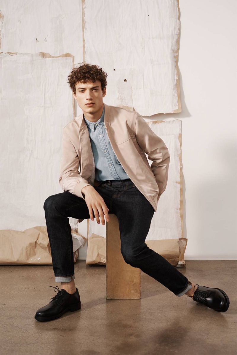 Going smart casual, Serge Rigvava models a Club Monaco bomber jacket, slim denim jeans, an oxford, and Wing + Horns shoes.