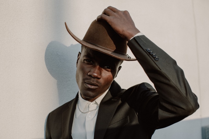 Remi wears cowboy hat Stetson, vintage French shirt, and sport coat Balmain.