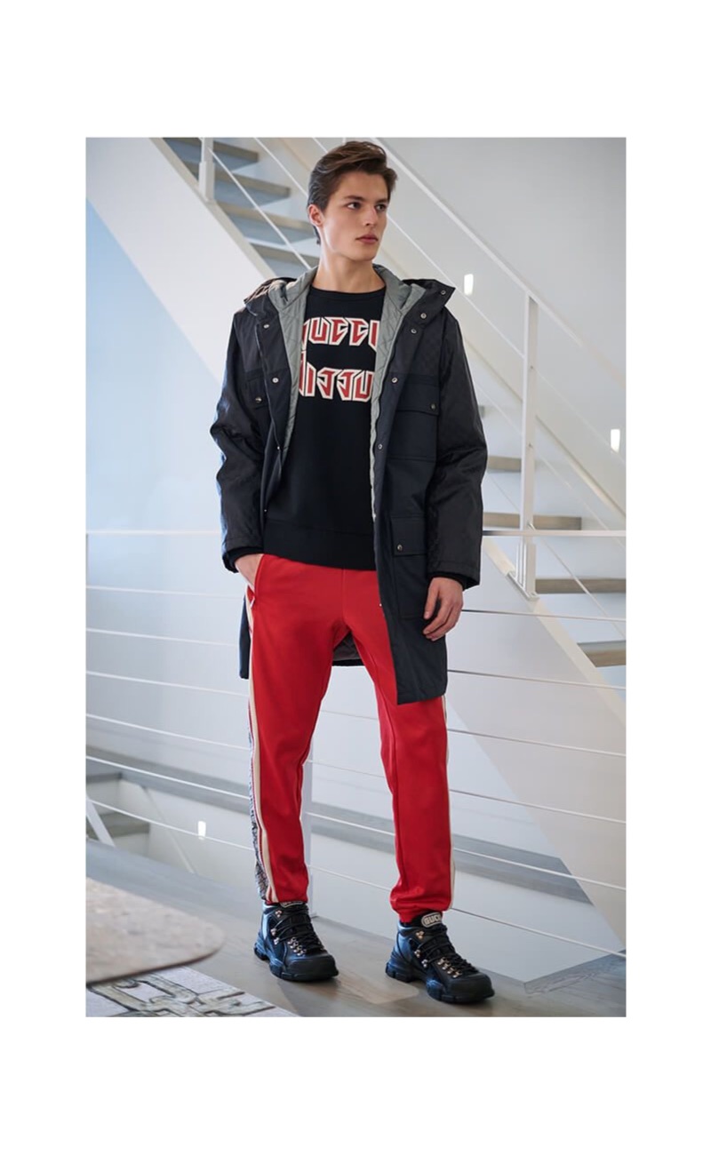 Model Brodie Scott wears a Gucci nylon jacket with a sweatshirt, joggers, and sneakers.