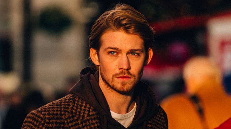 Captured out and about, Joe Alwyn dons an Incotex houndstooth coat, Fendi hoodie, and Mr P. t-shirt.
