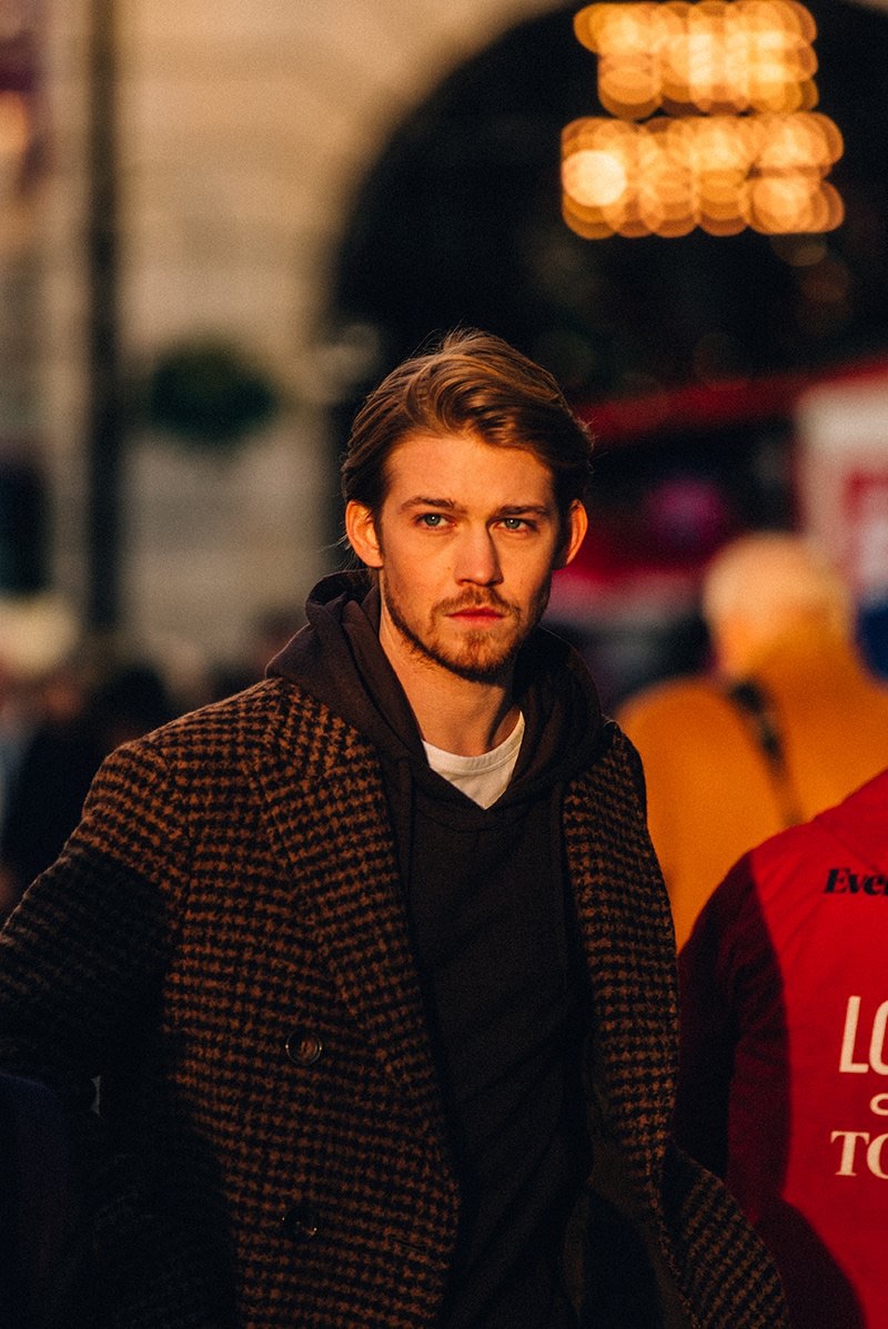 Captured out and about, Joe Alwyn dons an Incotex houndstooth coat, Fendi hoodie, and Mr P. t-shirt.