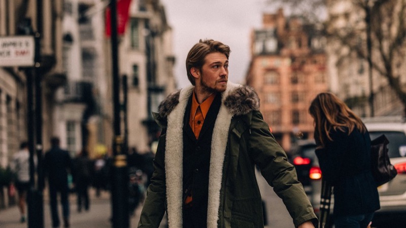 Joe Alwyn wears a Yves Salomon parka, Boglioli blazer, and Calvin Klein 205W39NYC shirt.