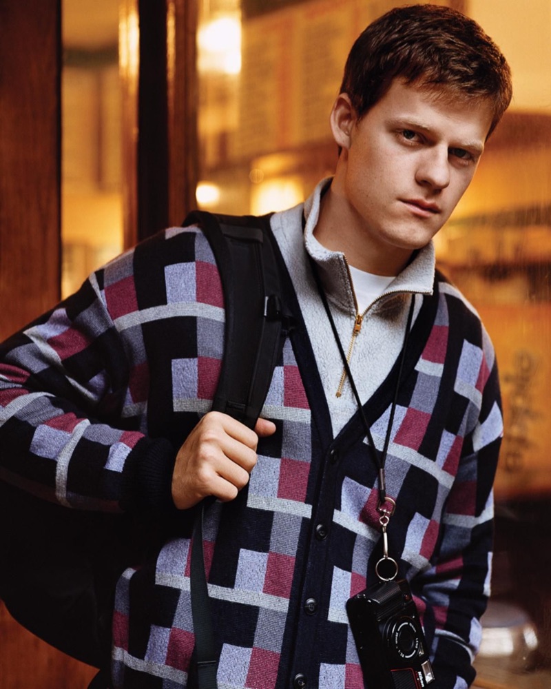 On the move, Lucas Hedges wears a Giorgio Armani cardigan, GmbH sweater, and Prada t-shirt.