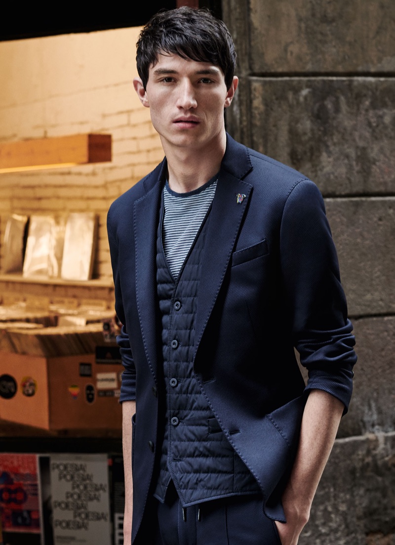 Jester White dons a navy suit with a quilted vest and striped tee by Digel Move.