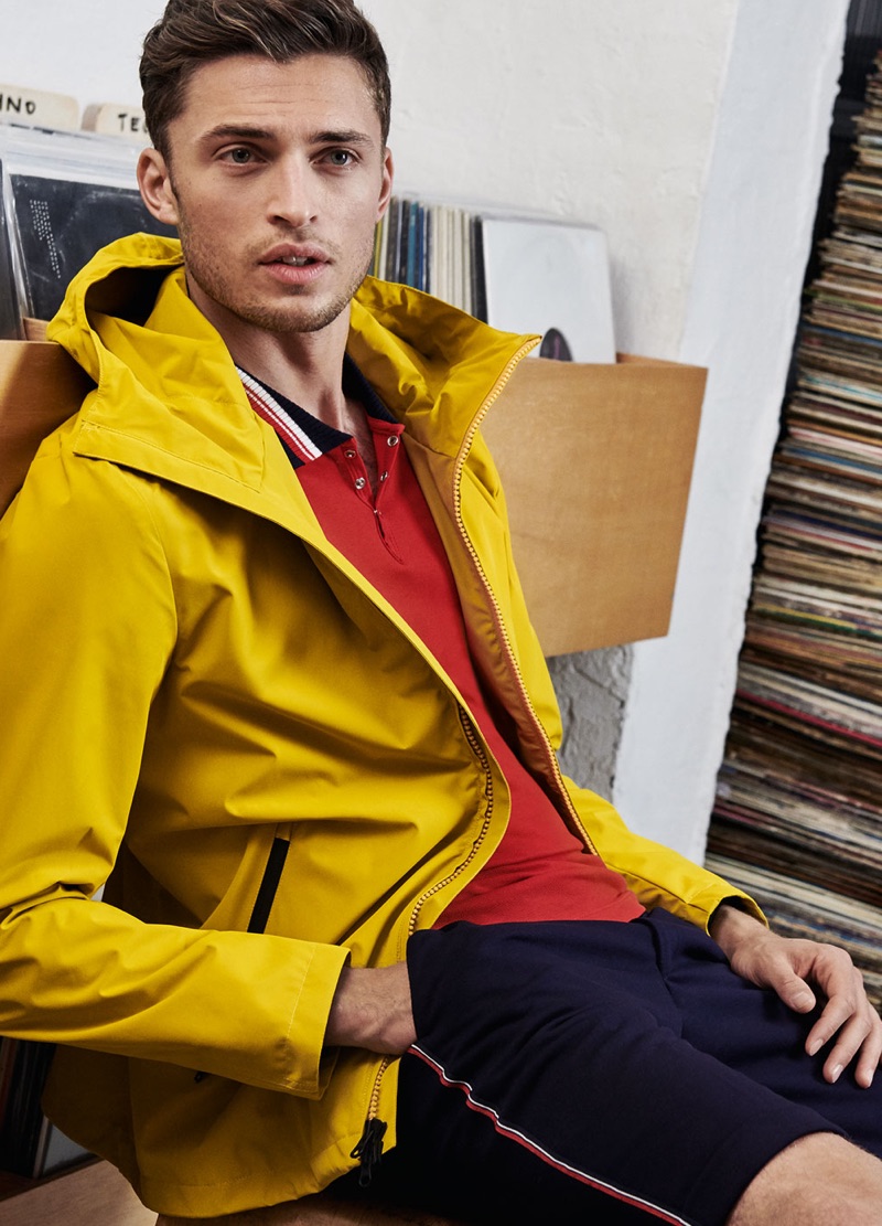 Wearing yellow, Harvey Haydon models a jacket with a red polo and navy shorts by Digel Move.