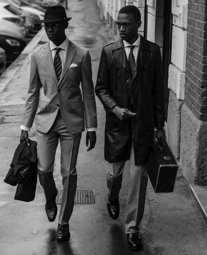 Left: Omar wears glasses Fielmann, hat Borsalino, two-button suit, shirt, tie, and shoes Salvatore Ferragamo. Right: Alejandro wears trench Salvatore Santoro, shoes Church's, two-button suit, shirt, and tie Salvatore Ferragamo.