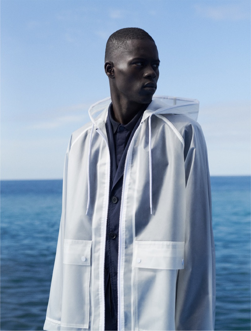 Model Alpha Dia wears a translucent white hooded jacket by Reserved.