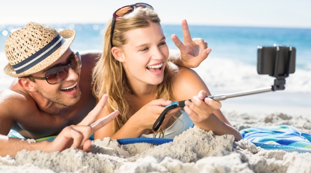 A Guide to Taking the Best Photos on Spring Break Selfie Stick Couple on Beach
