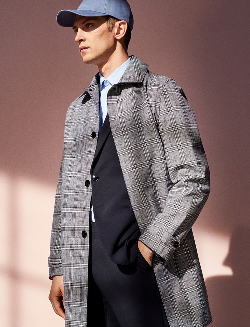 A sleek vision, Mathias Lauridsen wears a checked coat with a suit and cap.