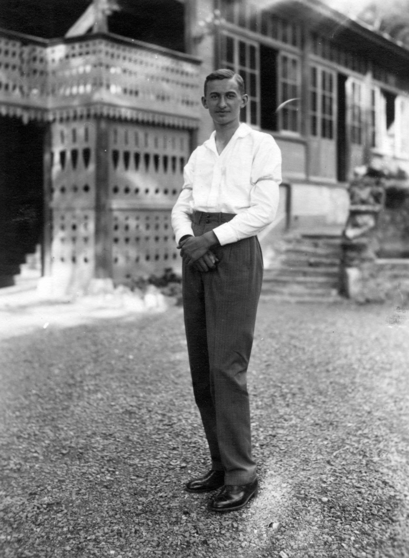 A young 1920s man wears a white shirt with the popular sleeve garters of the era.