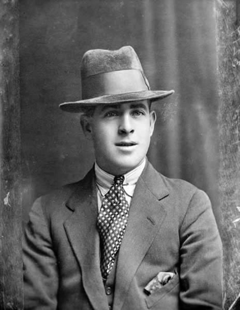 A photo thought to capture Fred Piper, whose father was a Steam Circus Proprietor. Here, he wears popular 1920s accessories such as a geometric print tie, collar pin, fedora, and a pocket square.