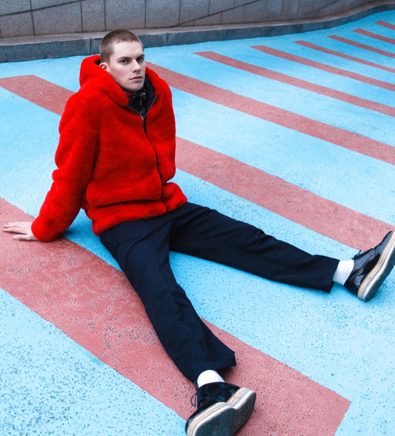 Alexander Morel wears a red fur jacket by PEACEMINUSONE with Prada pants and leather shoes.