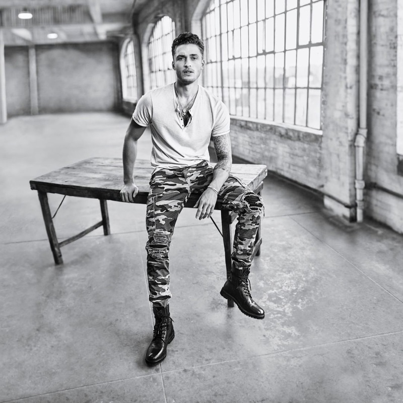 Sporting camouflage print pants, Harvey Haydon fronts Buffalo David Bitton's spring-summer 2019 campaign.