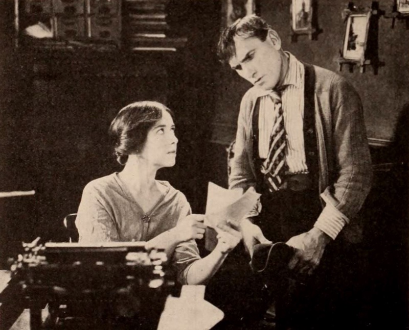 Appearing alongside Helen Jerome Eddy in the 1921 film One Man in a Million, actor George Beban wears a striped shirt with a diagonal striped tie, and ribbed cardigan sweater.