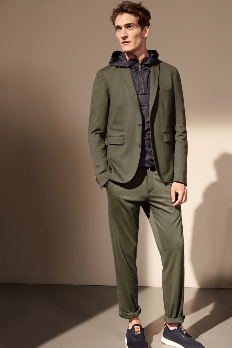 A modern vision, Matvey Lykov sports an olive colored suit with a windbreaker by Marc O'Polo.