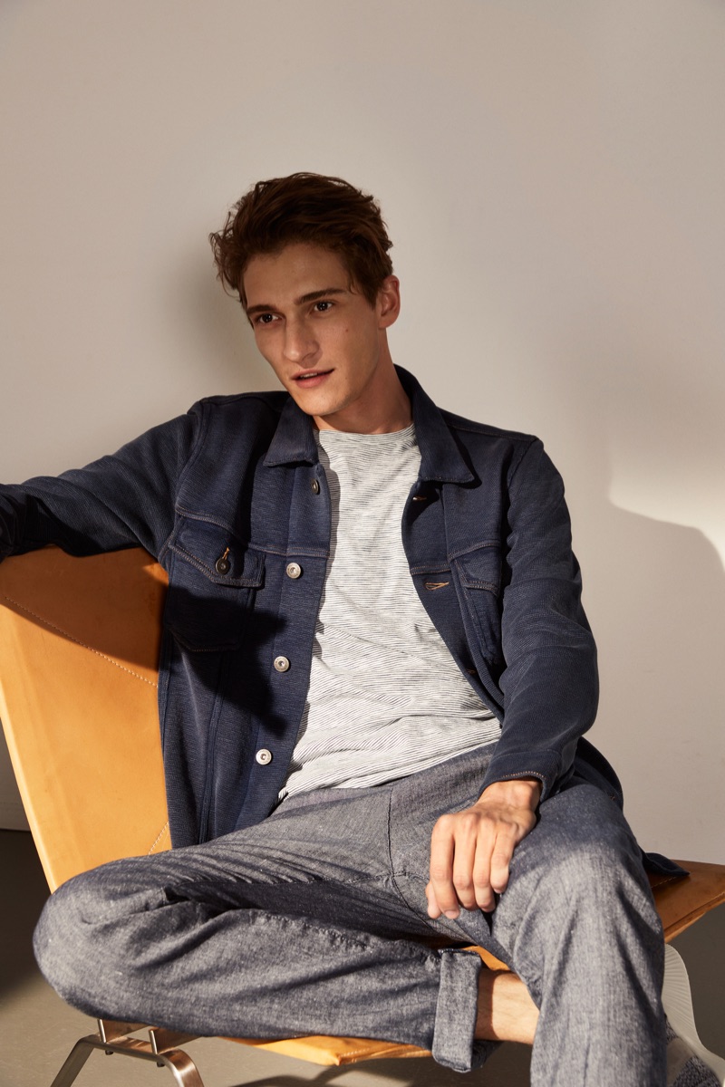 Going casual, Matvey Lykov sports a denim jacket, lightweight sweater, and linen trousers by Marc O'Polo.