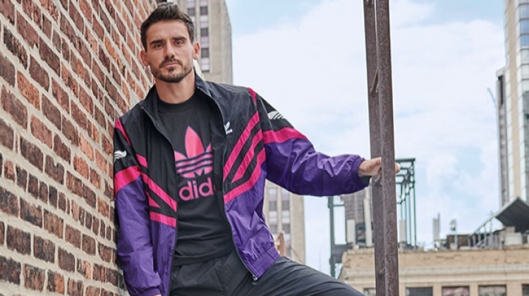 Channeling retro style, Arthur Kulkov rocks an adidas Originals sportive colorblocked track jacket, trackpants, and treifoil logo t-shirt.
