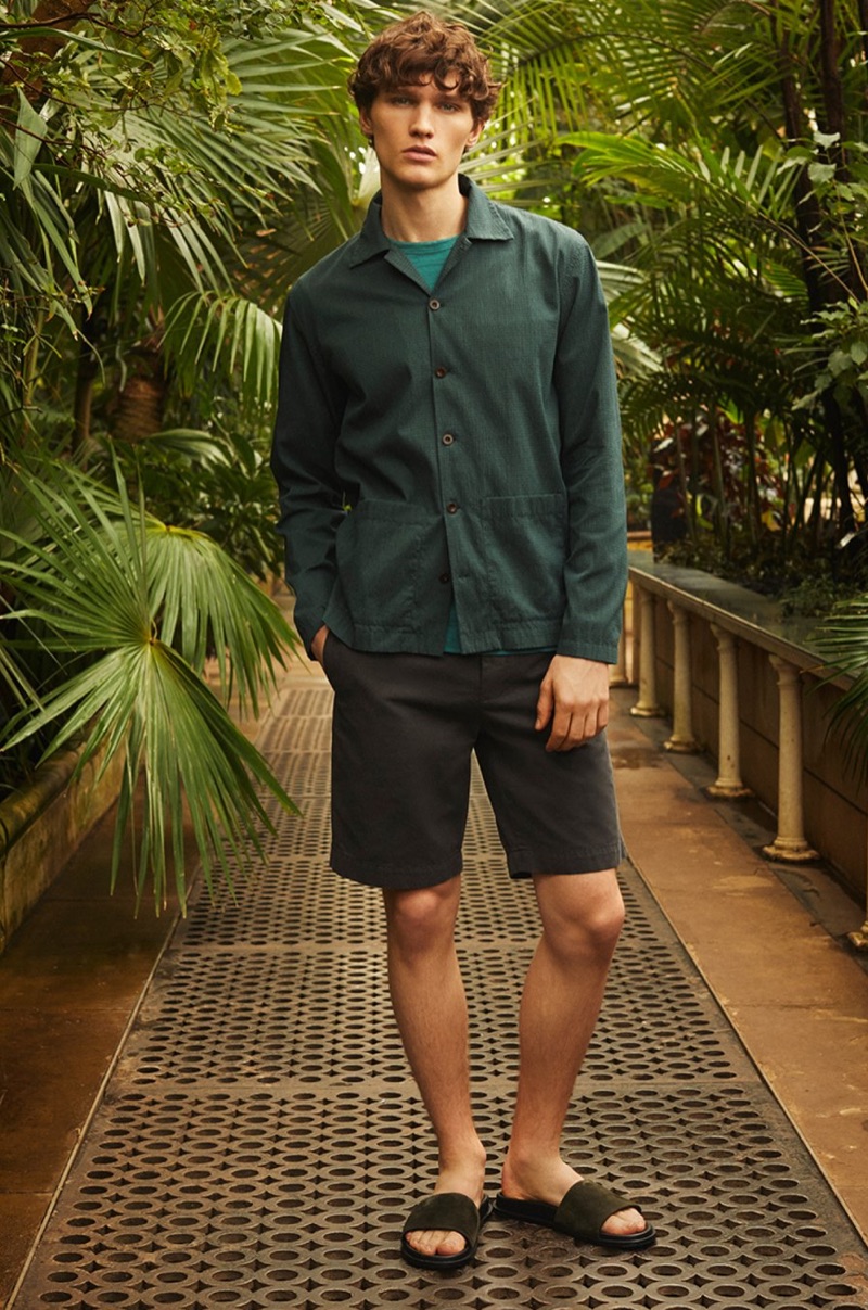 Connecting with Mr Porter, Lukas Marschall wears a Mr P. t-shirt, Bermuda shorts, seersucker pocket shirt, and suede sandals.