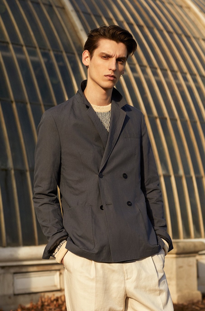 Model Anthony Gilardot sports a double-breasted suit jacket, striped sweater, and trousers from Mr P.