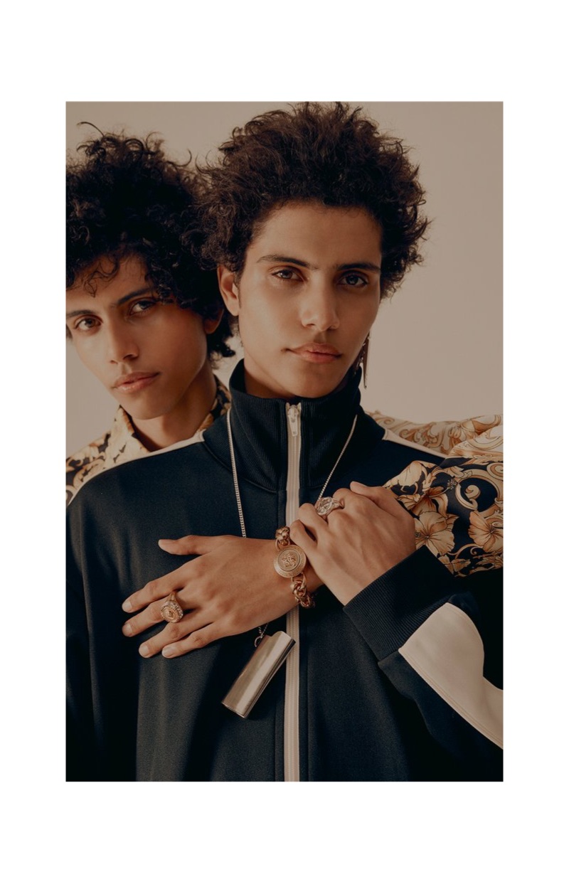 Front and center, Trent rocks an Ambush striped satin-jersey track jersey and a pendant necklace with a Versace gold-tone ring.