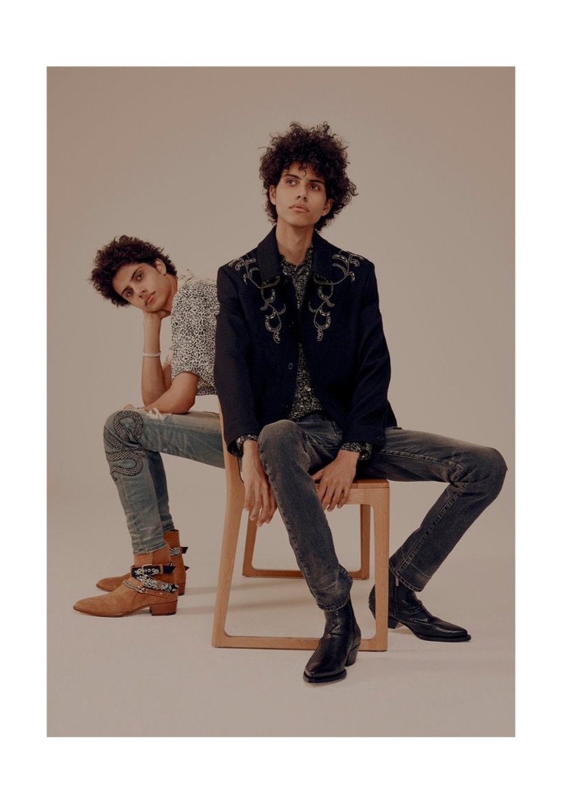 Left: Trent models an AMIRI camp-collar shirt, denim jeans, and suede boots with an Alexander McQueen silver-tone ID bracelet. Right: Piers wears a Saint Laurent wool-brocade jacket, silk crêpe shirt, and denim jeans with Givenchy leather Chelsea boots.