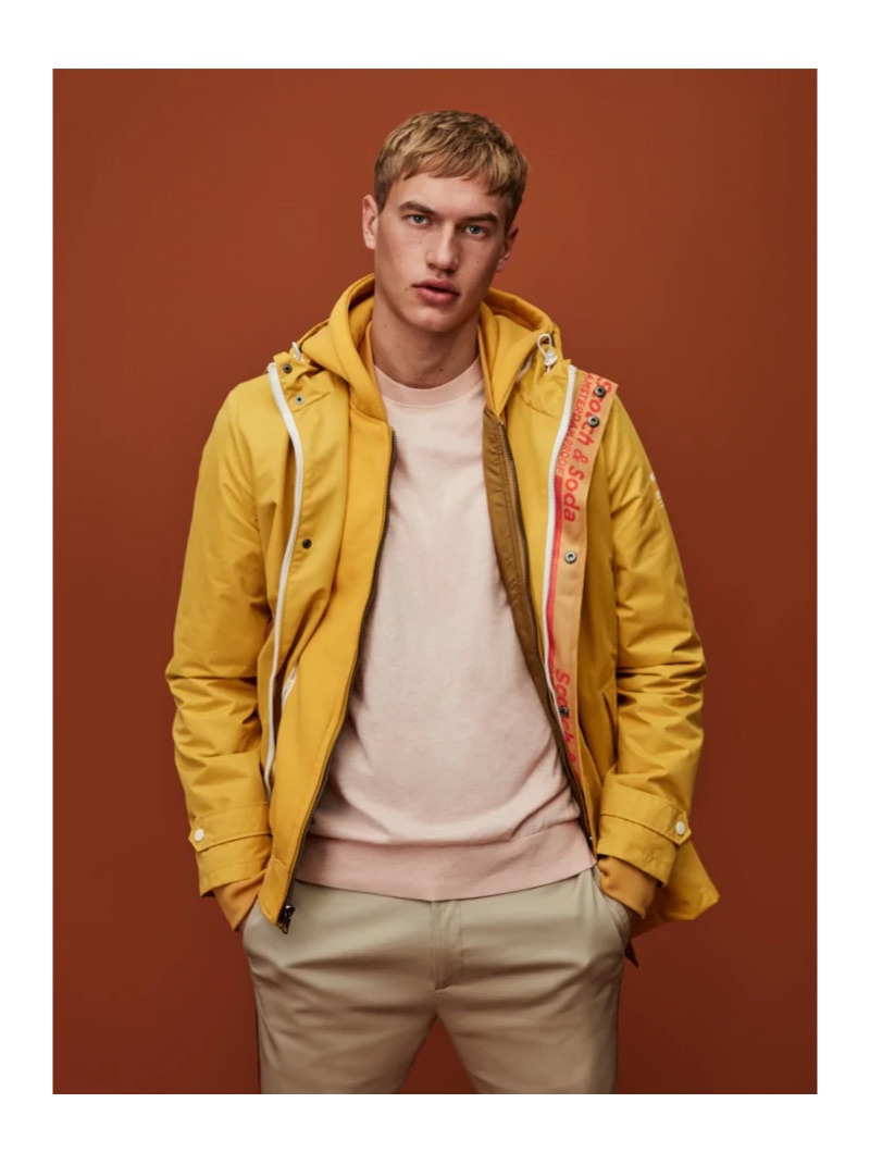 Embracing a pop of color, Paul François wears a yellow rain parka by Scotch & Soda.